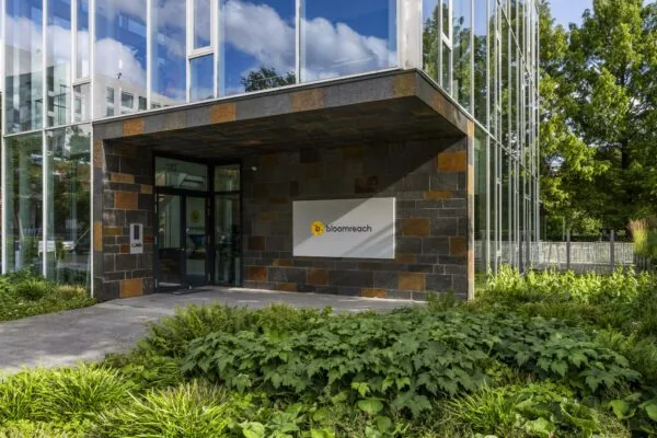 Entree van het kantoorgebouw van Bloomreach aan de Fred. Roeskestraat, met moderne gevel en omliggende beplanting.